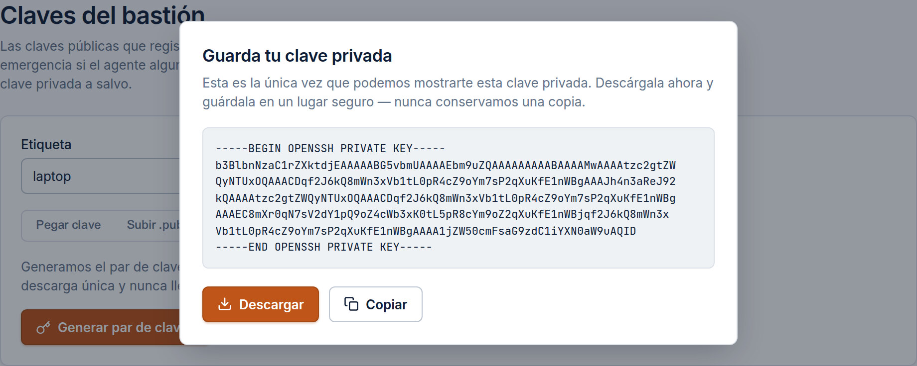 Un diálogo "Guarda tu clave privada" sobre la página de Claves del bastión: un bloque OPENSSH PRIVATE KEY que se muestra una única vez con el aviso "Esta es la única vez que podemos mostrarte esta clave privada. Descárgala ahora y guárdala en un lugar seguro — nunca conservamos una copia.", y botones Descargar / Copiar.